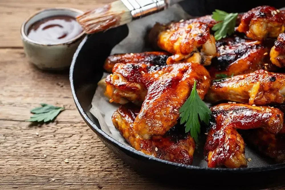 Delicious hickory-smoked barbecue chicken wings with dipping sauce.