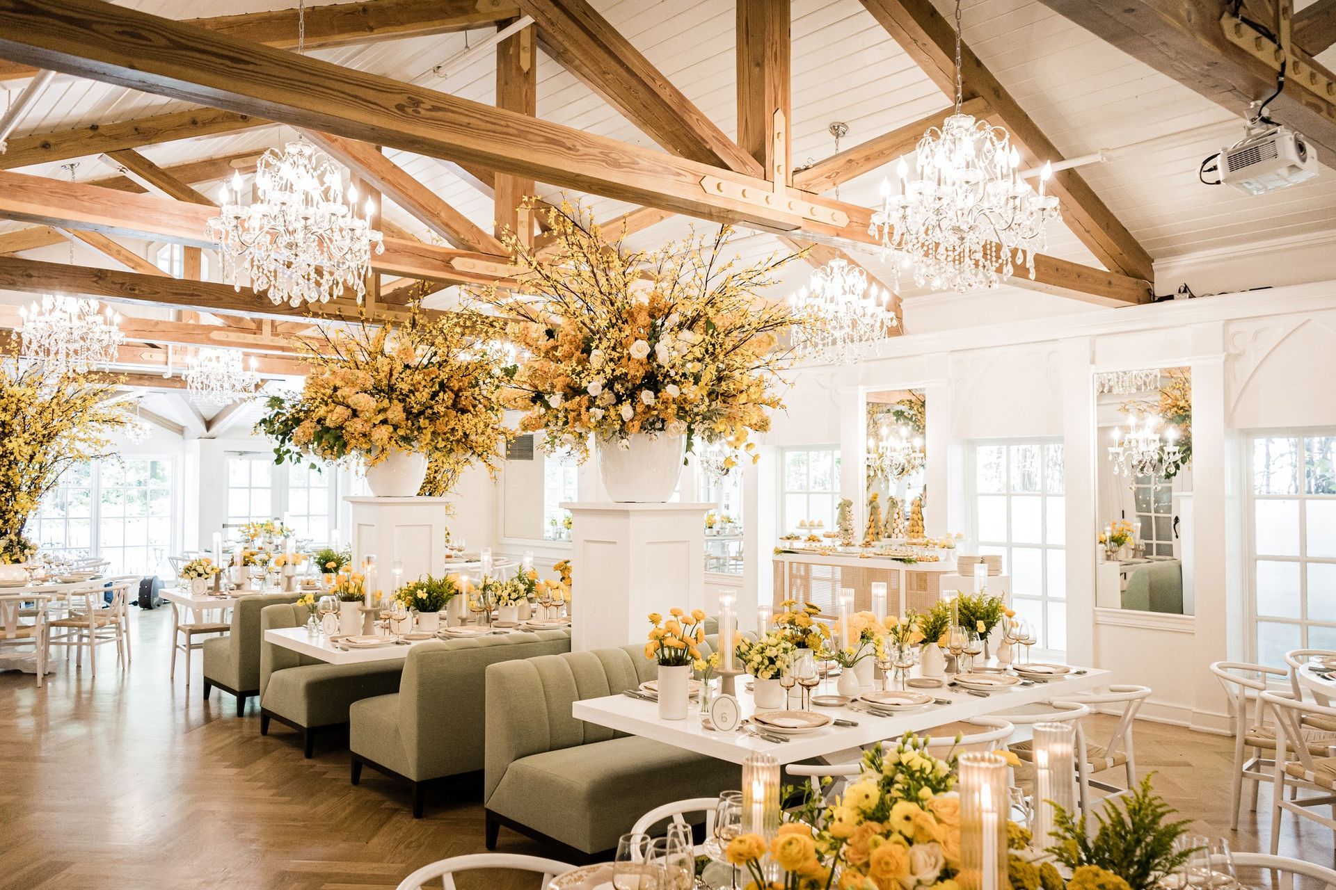 A large room filled with tables , chairs , candles and flowers.