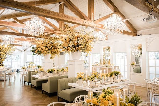 A long table with plates , candles , and flowers on it.