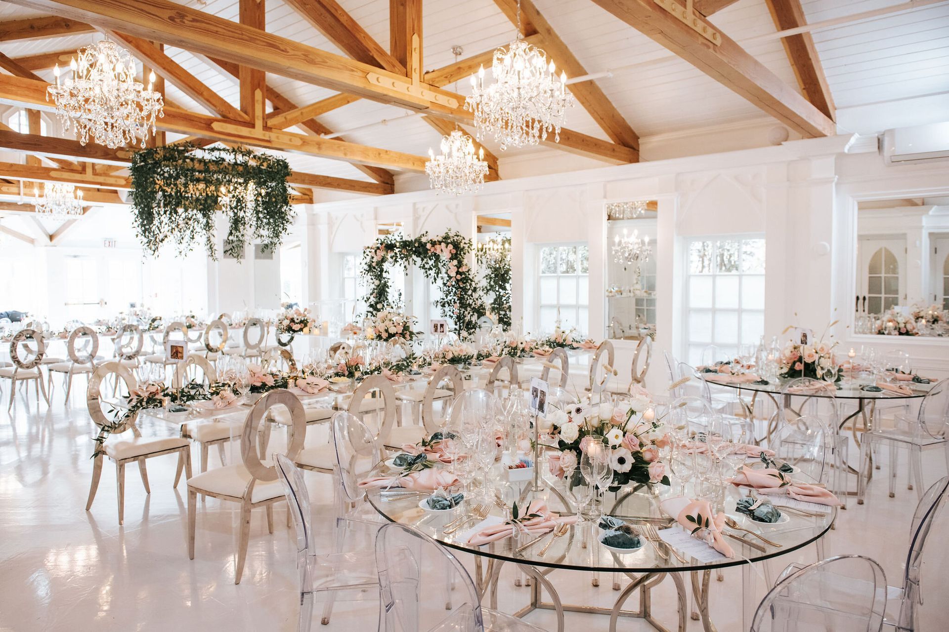 A large room with tables and chairs set up for a wedding reception.