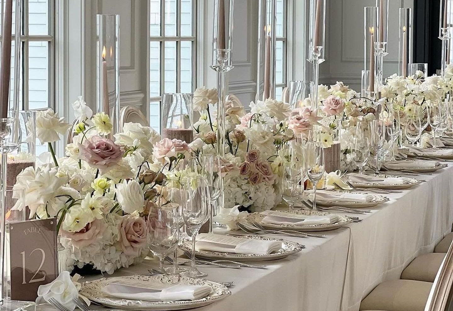 A long table with plates , candles and flowers on it