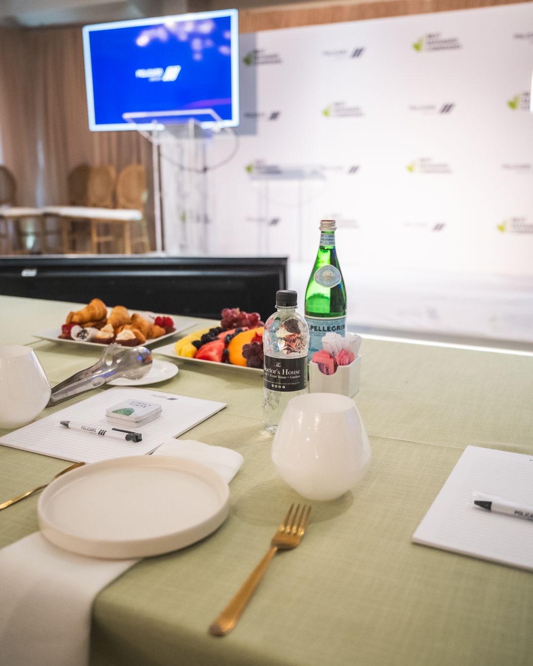 A table with a plate of fruit and a bottle of water