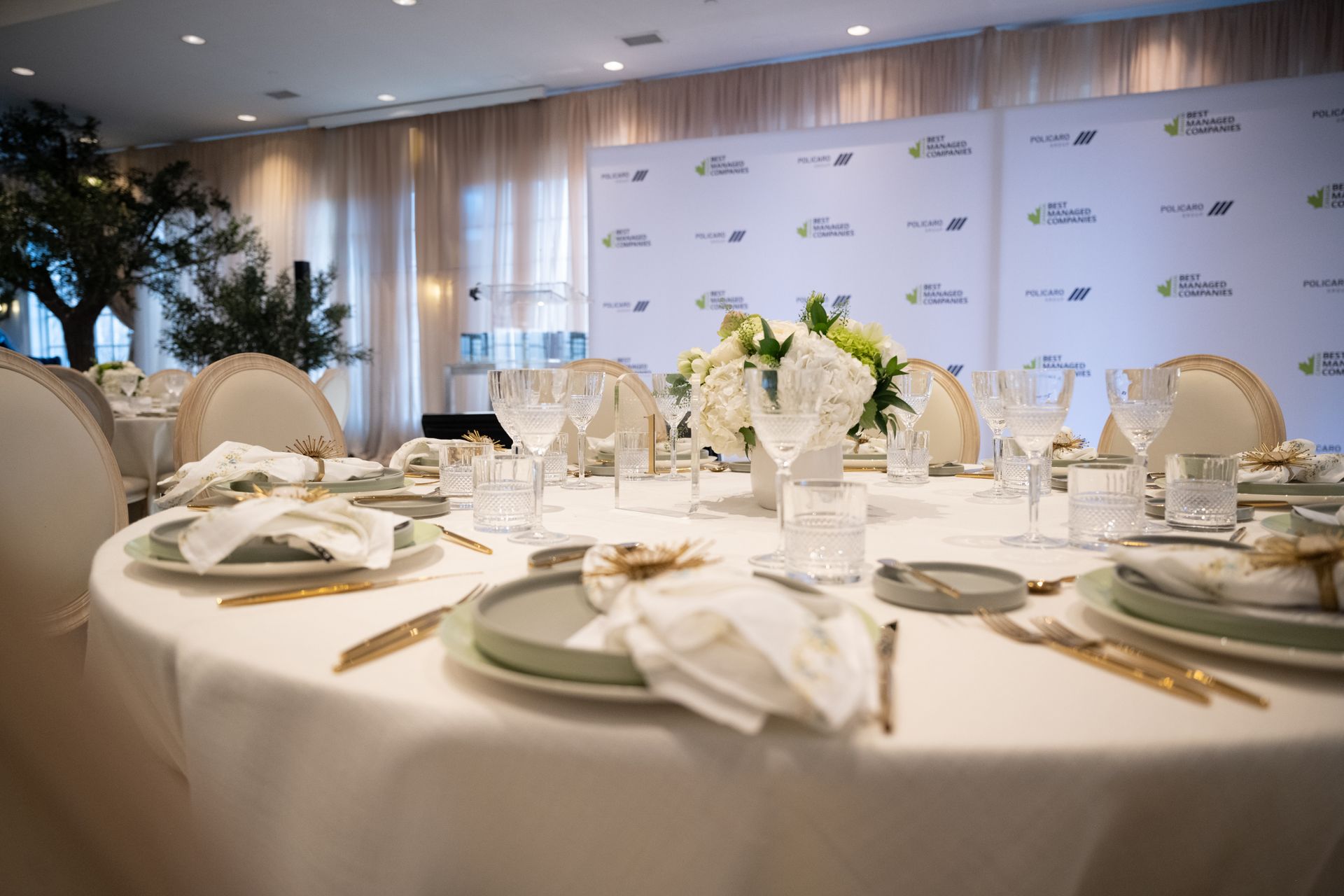 A large room with tables and chairs set up for a wedding reception.