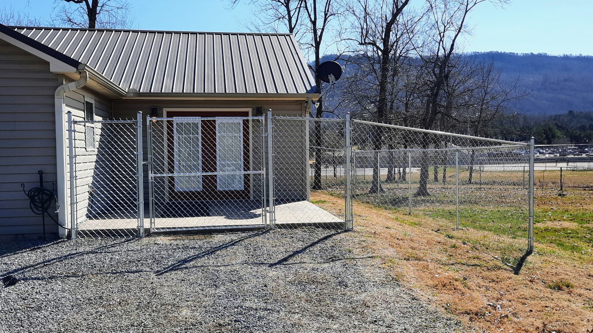 A small house with a chain link fence around it.