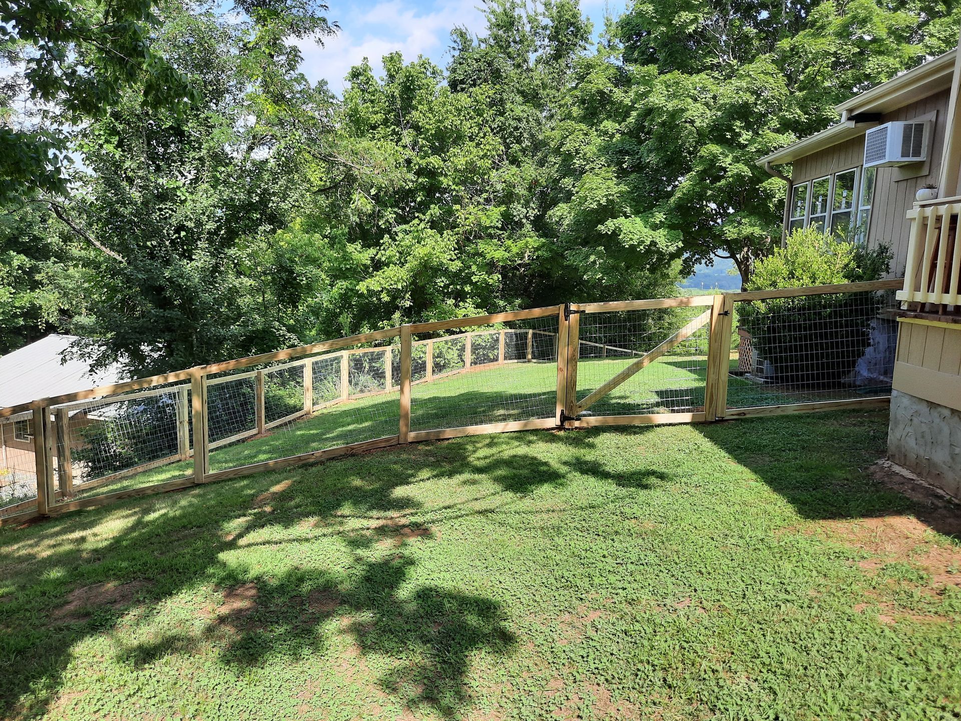 There is a wooden fence in the backyard of a house.