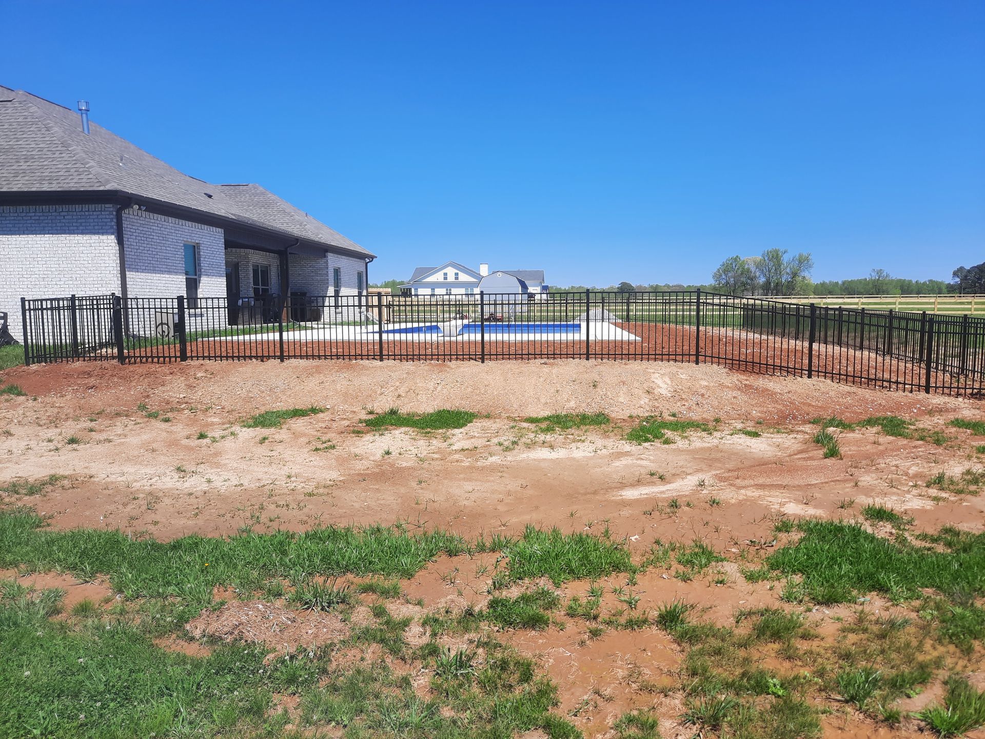 A house with a fence around it and a pool in the backyard.