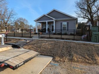 A house with a trailer parked in front of it.