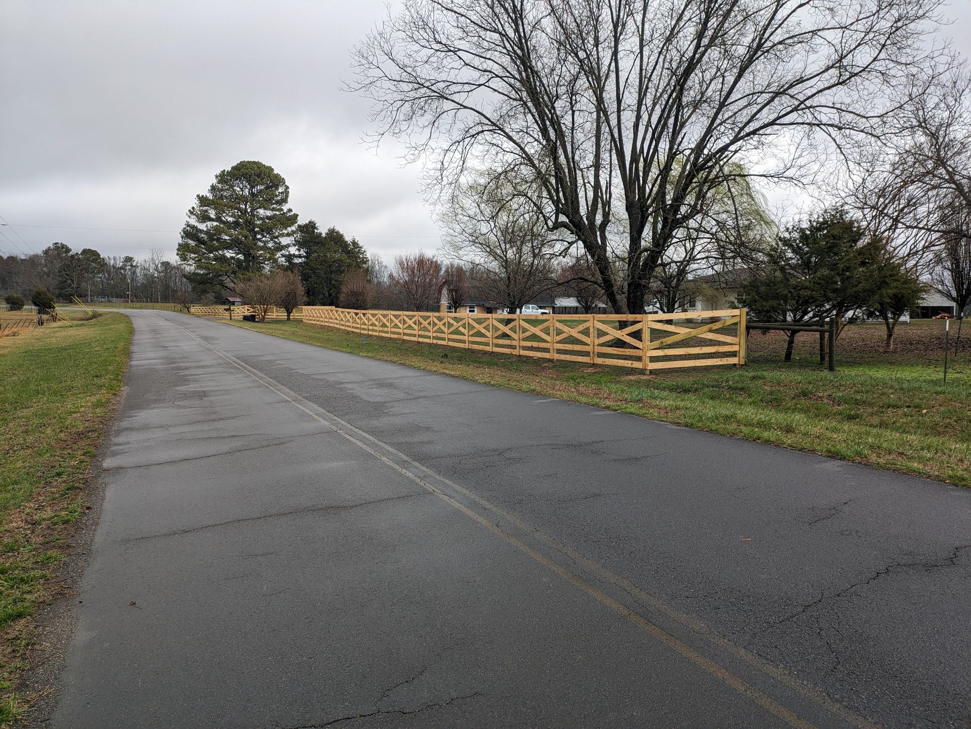 A wooden fence along the side of a road.