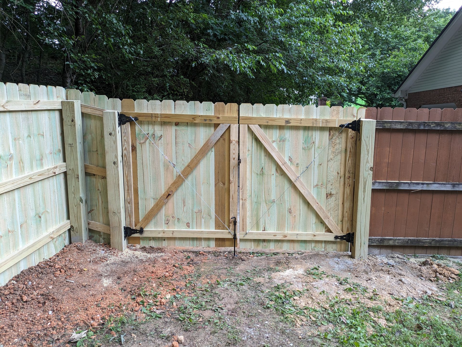 A wooden fence with a gate in the backyard.