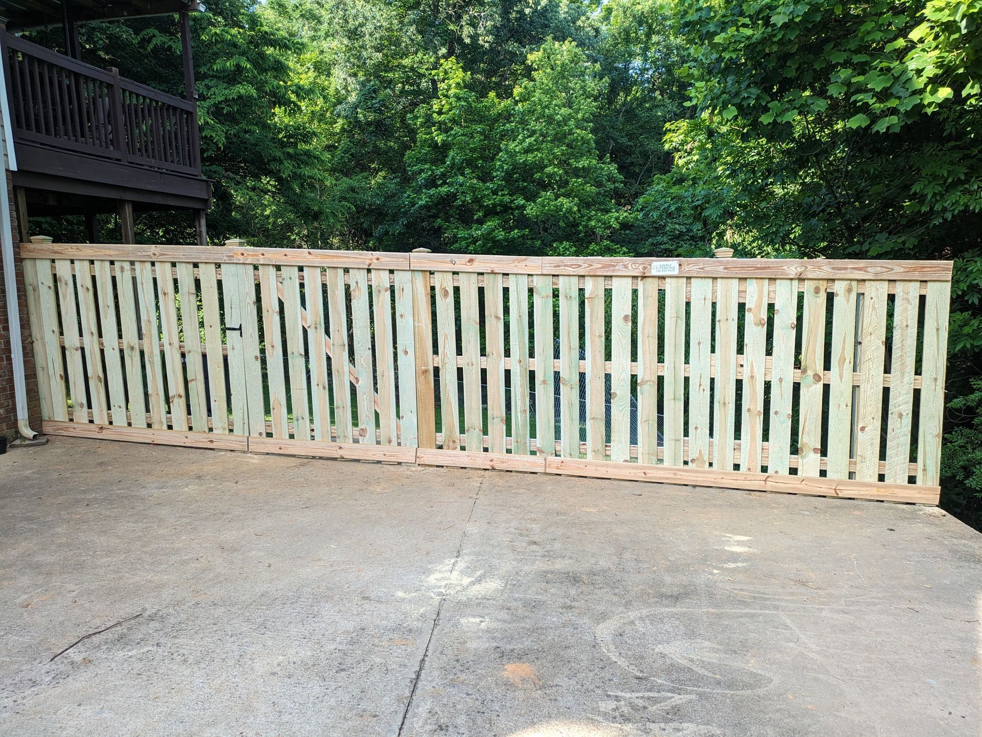 A wooden fence is sitting on top of a concrete driveway.