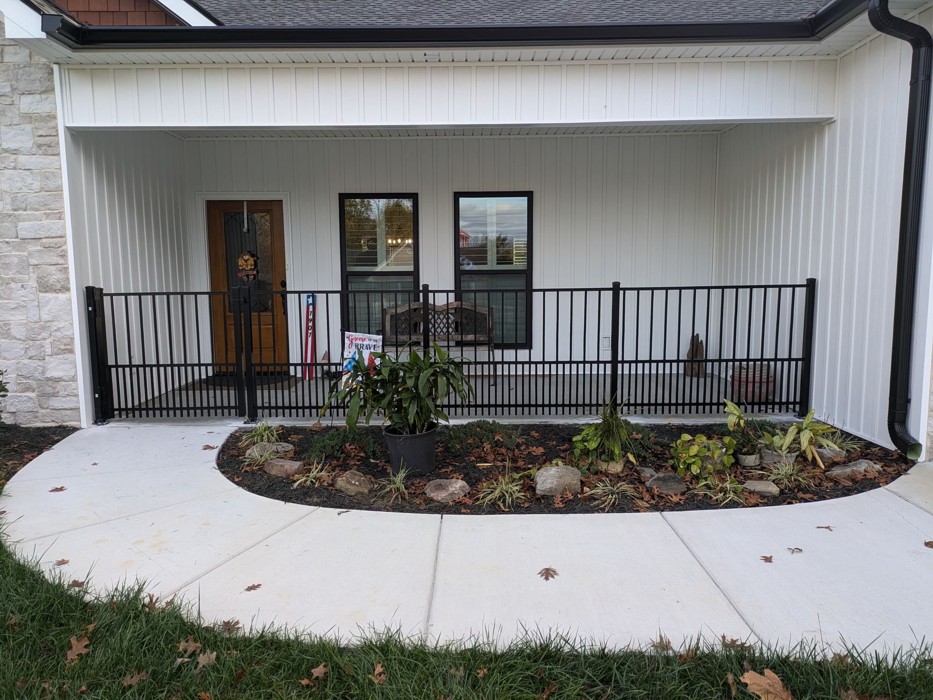 A white house with a porch and a black railing