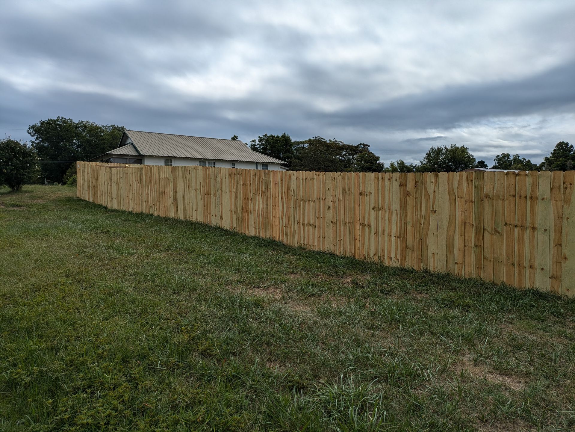 A wooden fence is sitting in the middle of a grassy field.