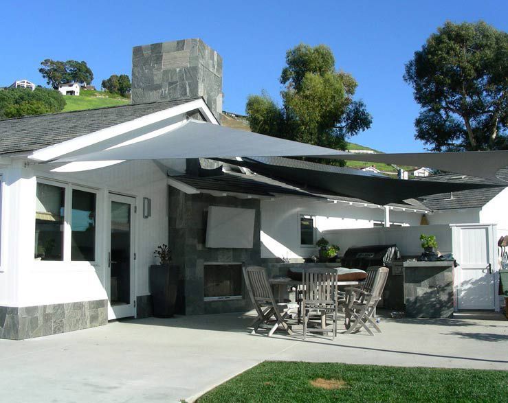 A Patio With A Table And Chairs Under Sun Shade — Shades of Blue In North Wyong, NSW