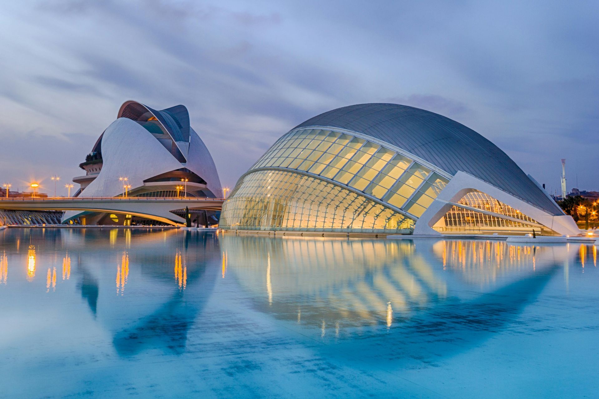 Modern, futuristic buildings reflected in water in Valencia, Spain; blue dusk sky.