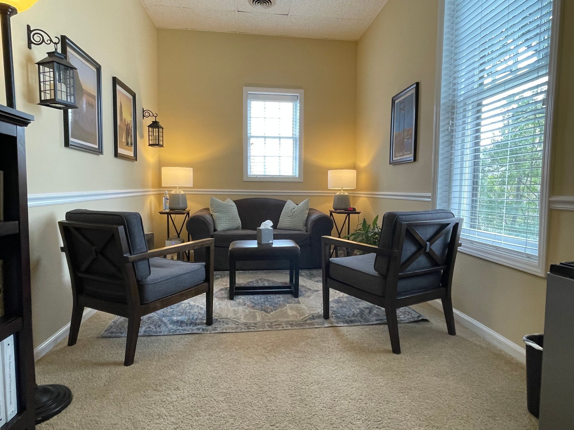 A living room with a couch , chairs , and a coffee table.