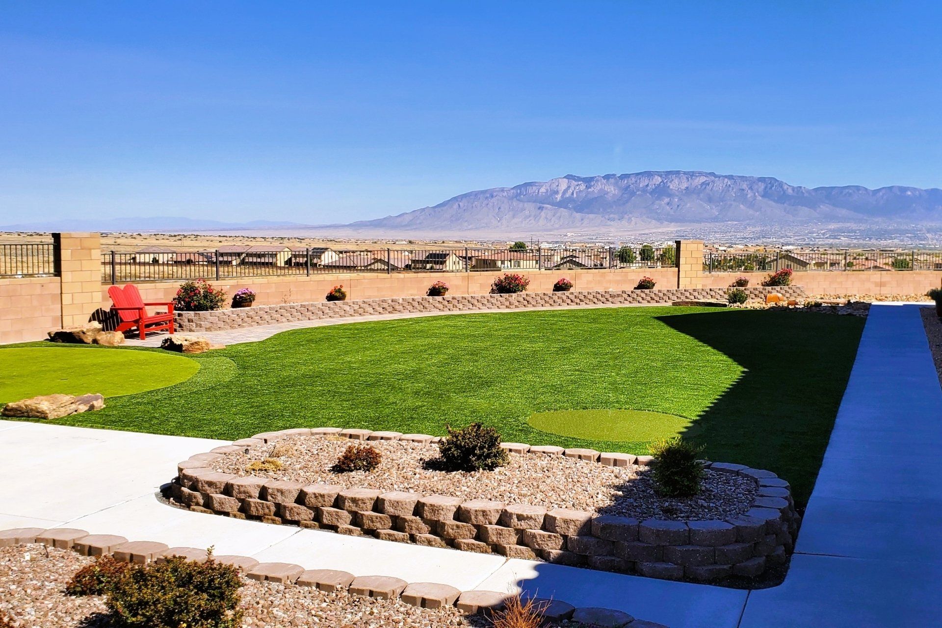 A lush green lawn with mountains in the background