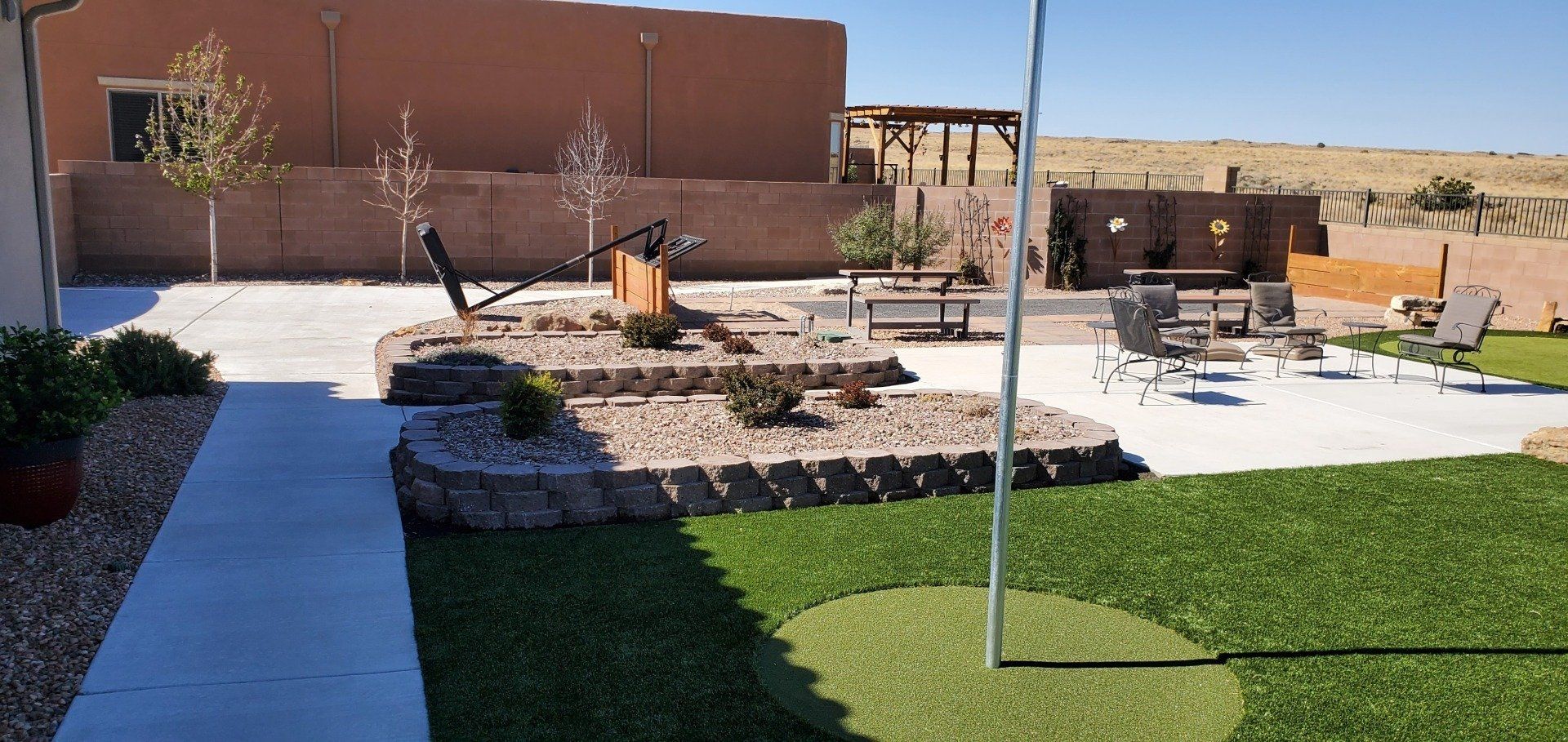 A backyard with a concrete walkway and a swing set.
