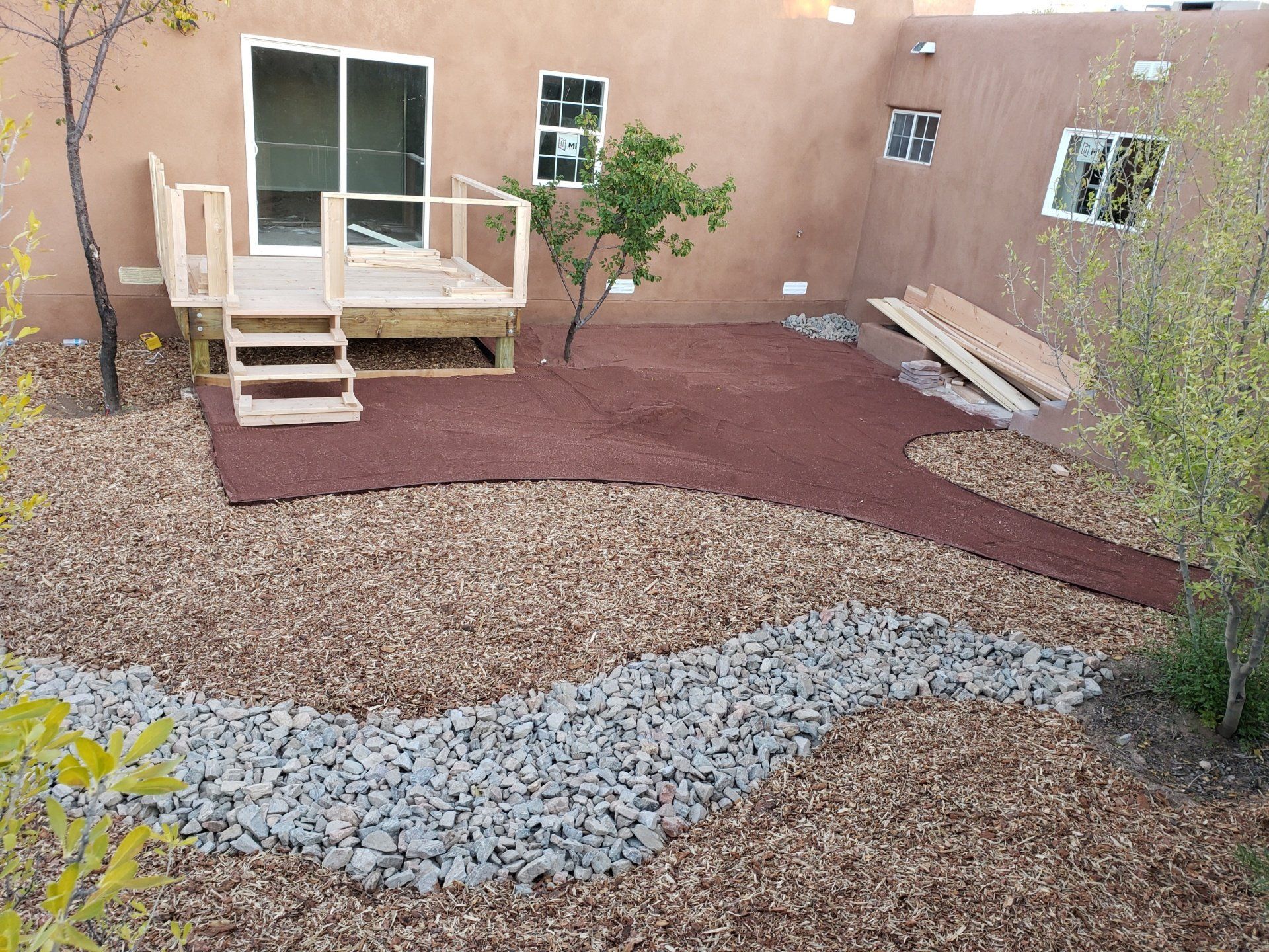 A backyard with a wooden deck and stairs