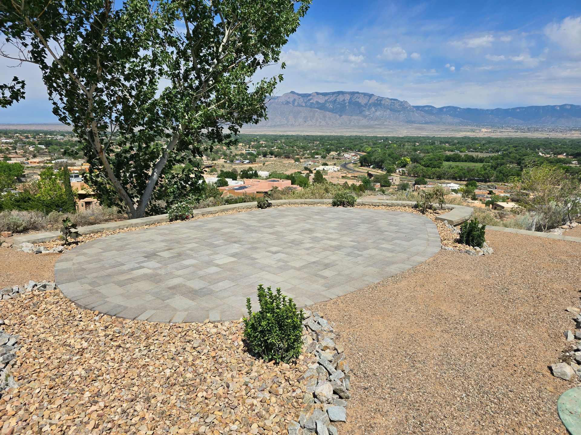 A gravel area with a view of a city and mountains
