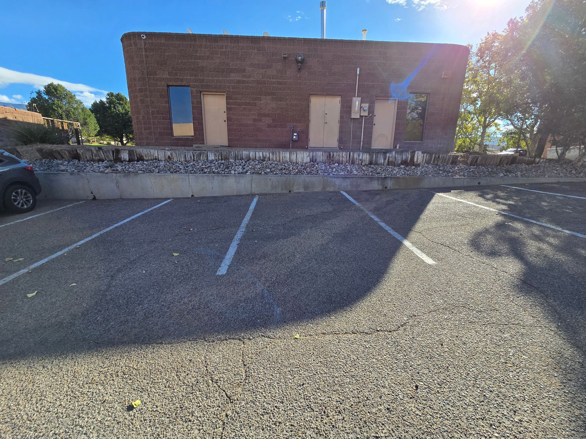 A car is parked in a parking lot in front of a building.