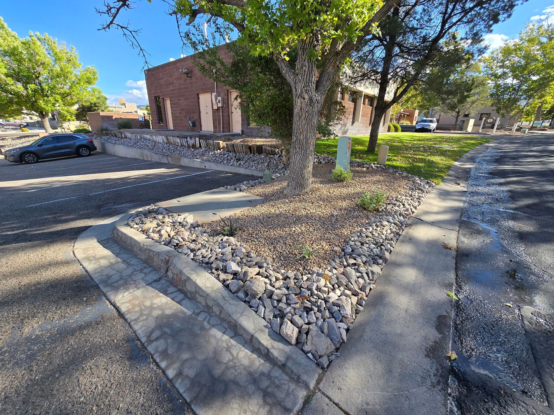A car is parked on the side of the road in front of a building.