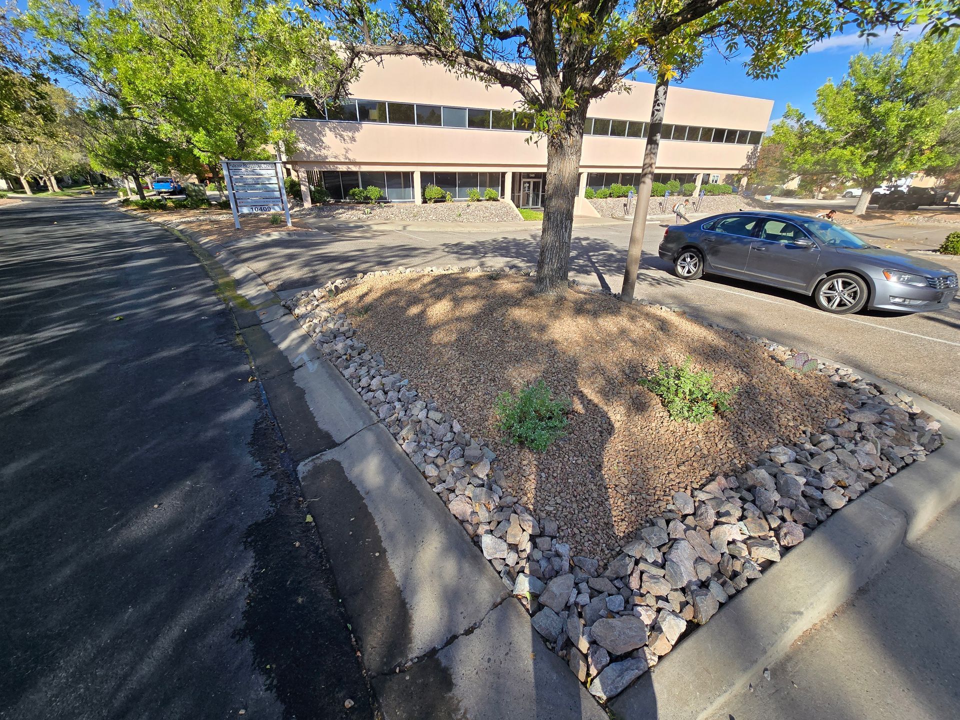 A car is parked in a parking lot in front of a building.