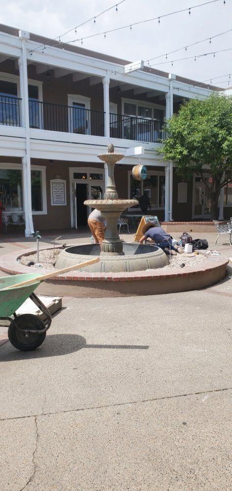A fountain is being built in a courtyard in front of a building.