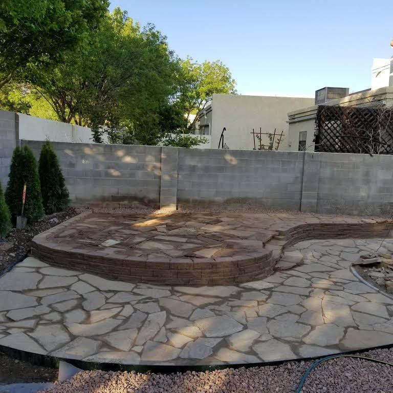 A stone patio with a brick wall in the background