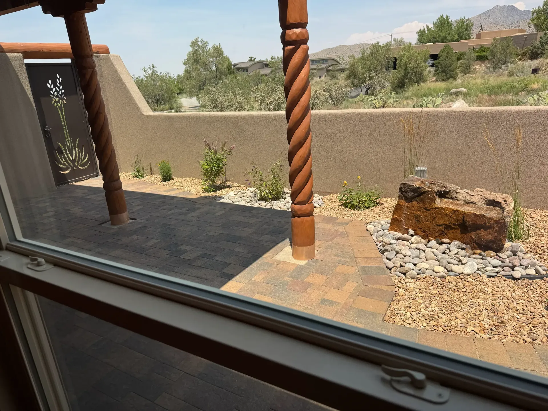 A window with a view of a patio and mountains
