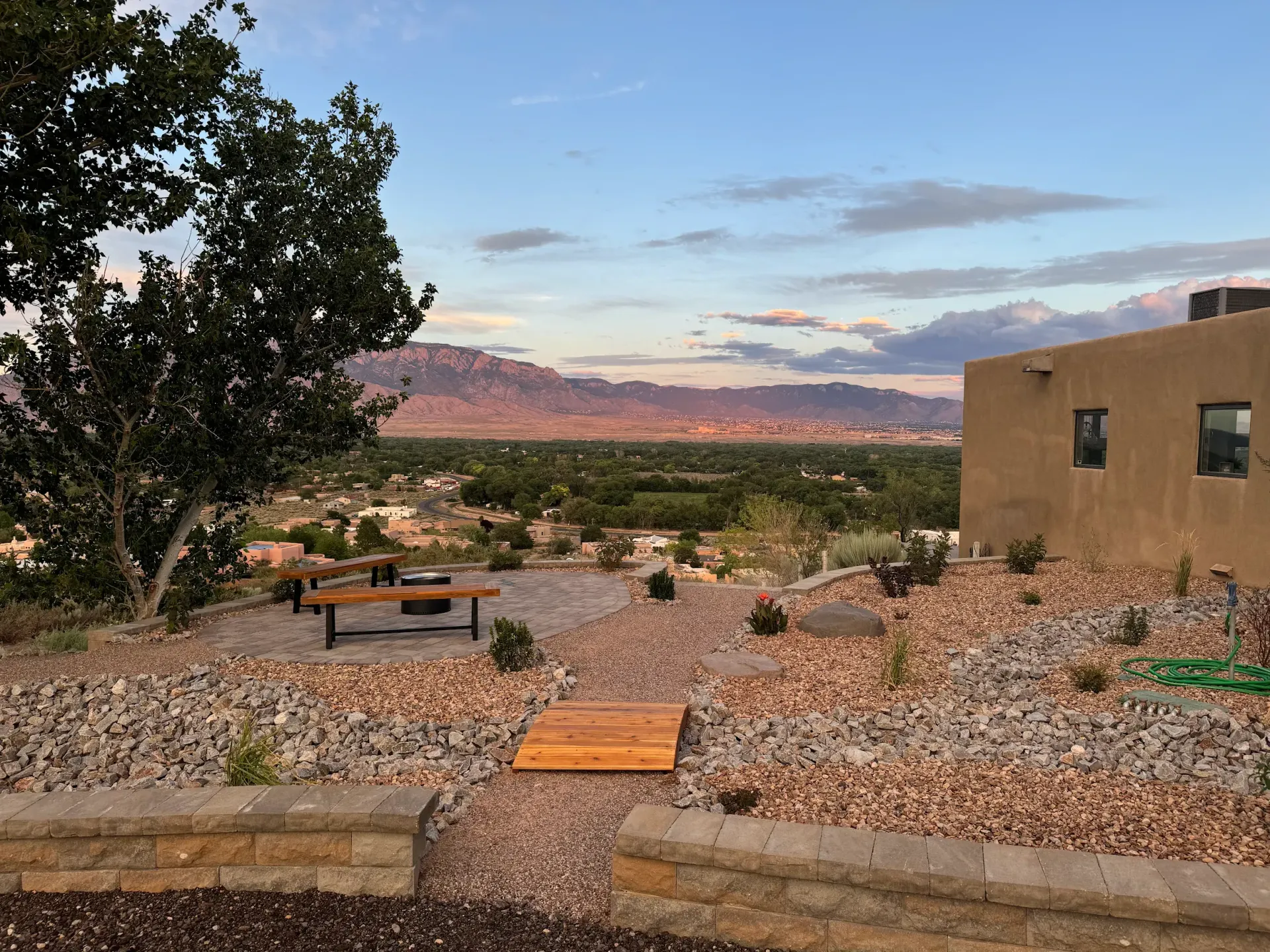 A house is sitting on top of a rocky hill with a view of the mountains.