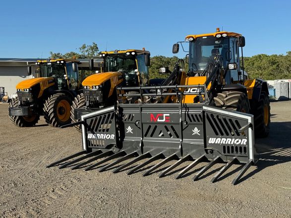 Three yellow JCB agricultural tractors parked on a gravel lot, the front one equipped with a large black