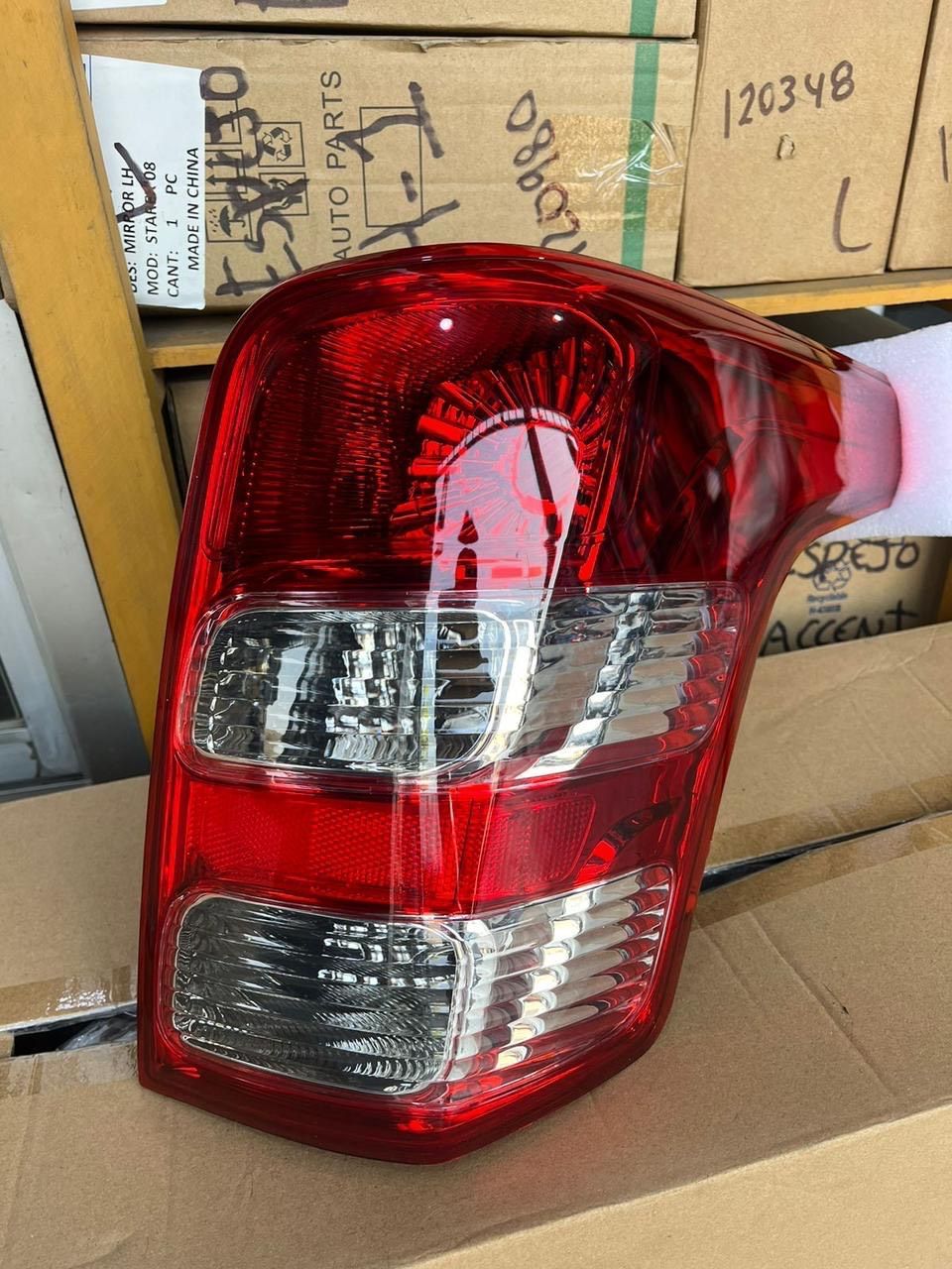 Luz trasera de automóvil roja y clara, vista en ángulo, contra cajas.