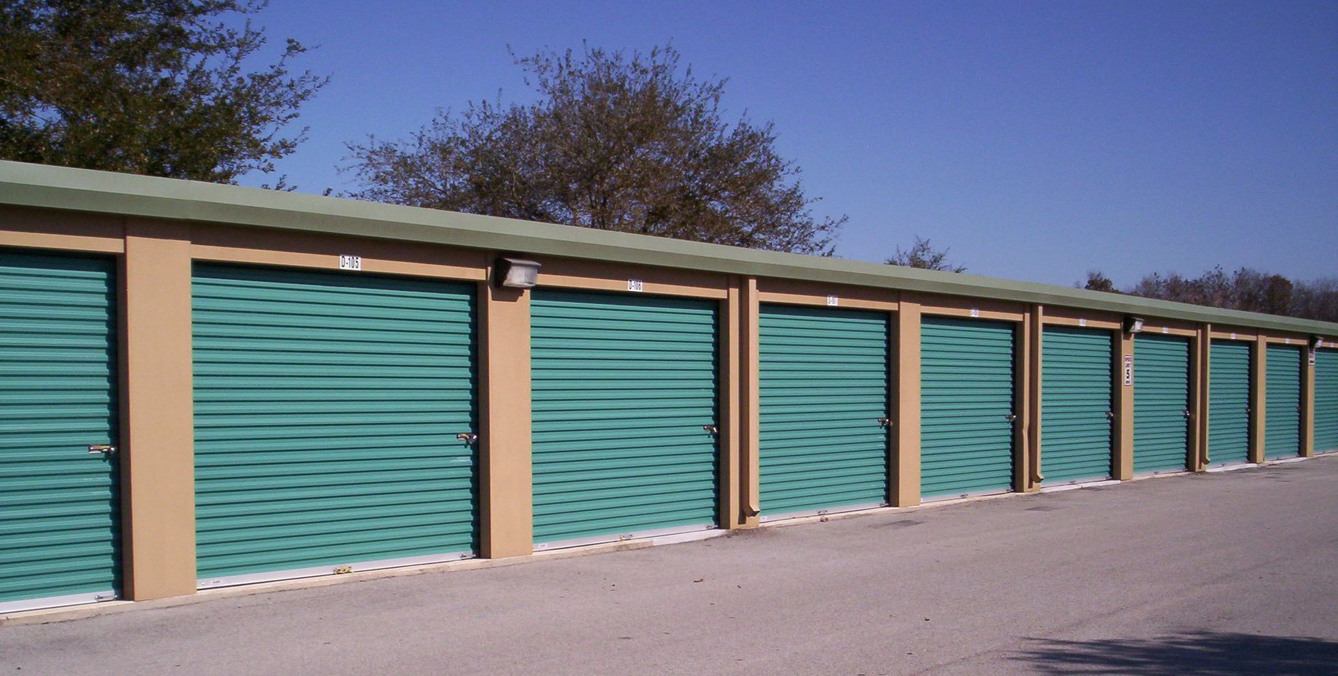 A row of green garage doors on a sunny day