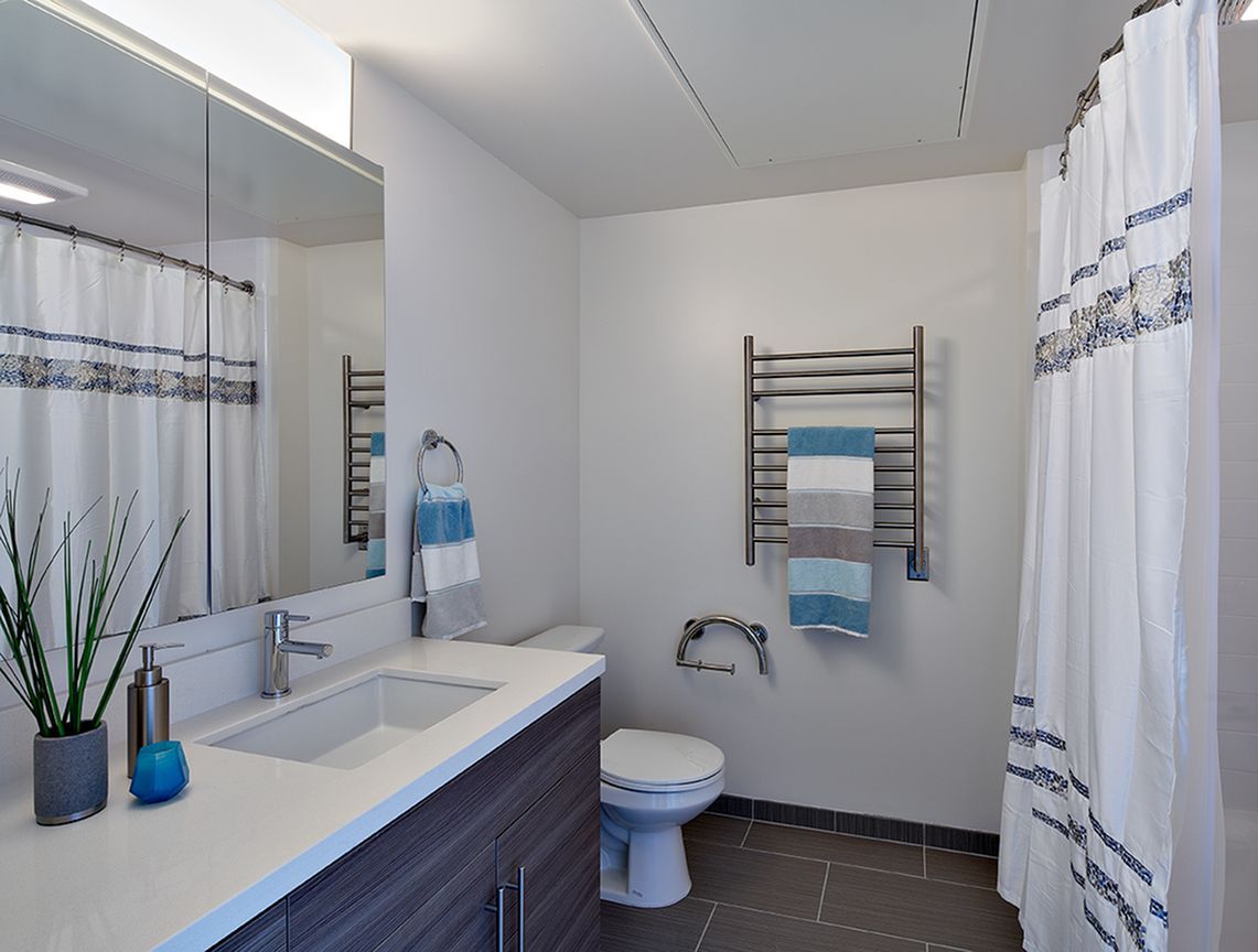 A bathroom with a toilet a sink and a shower curtain