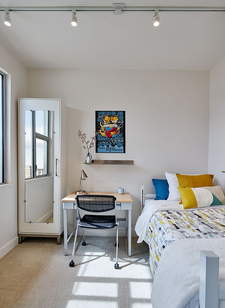 A bedroom with two beds a desk and a mirror