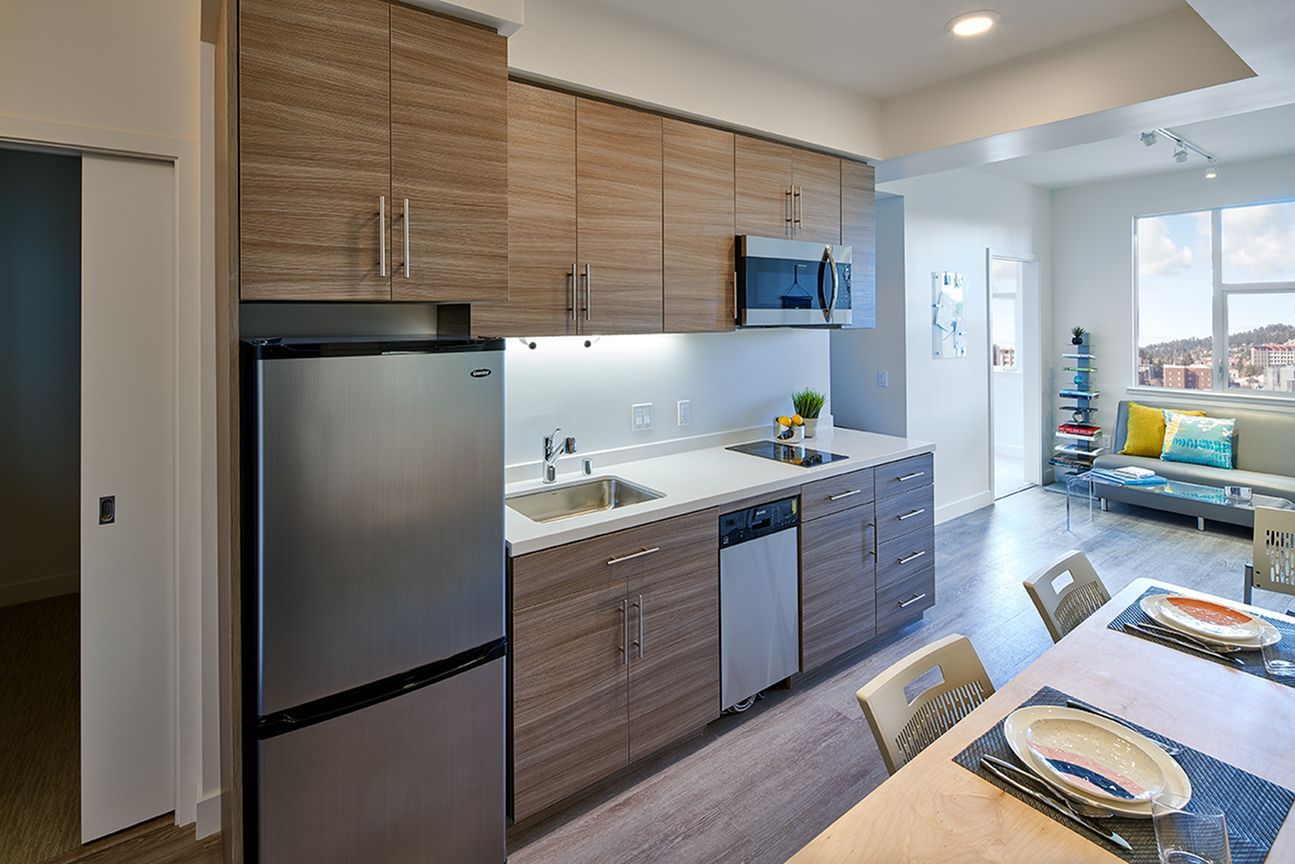 A kitchen with stainless steel appliances and wooden cabinets.