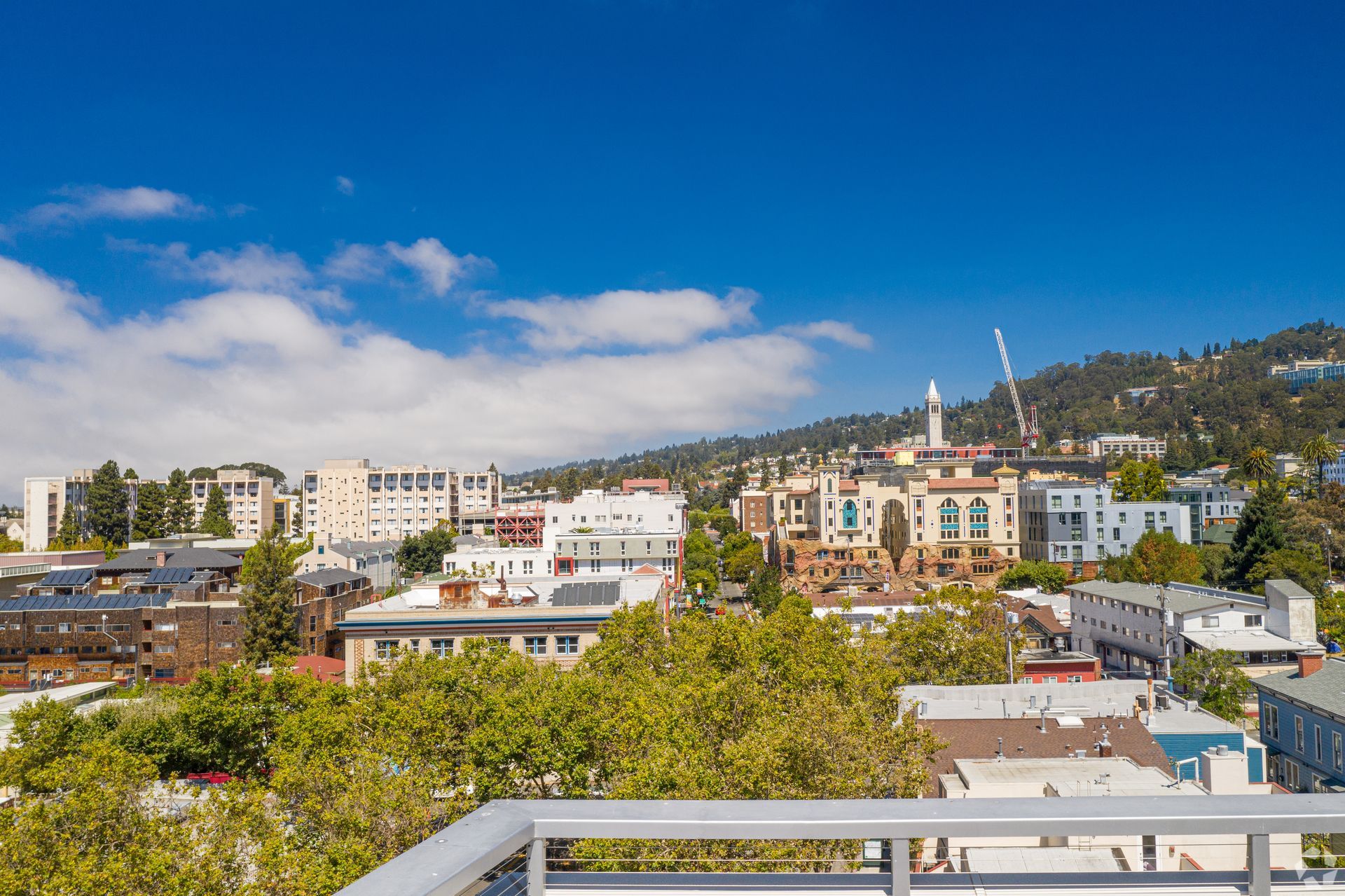 A view of a city from a balcony on a sunny day.