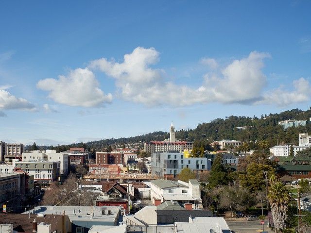An aerial view of a city with a blue sky and clouds