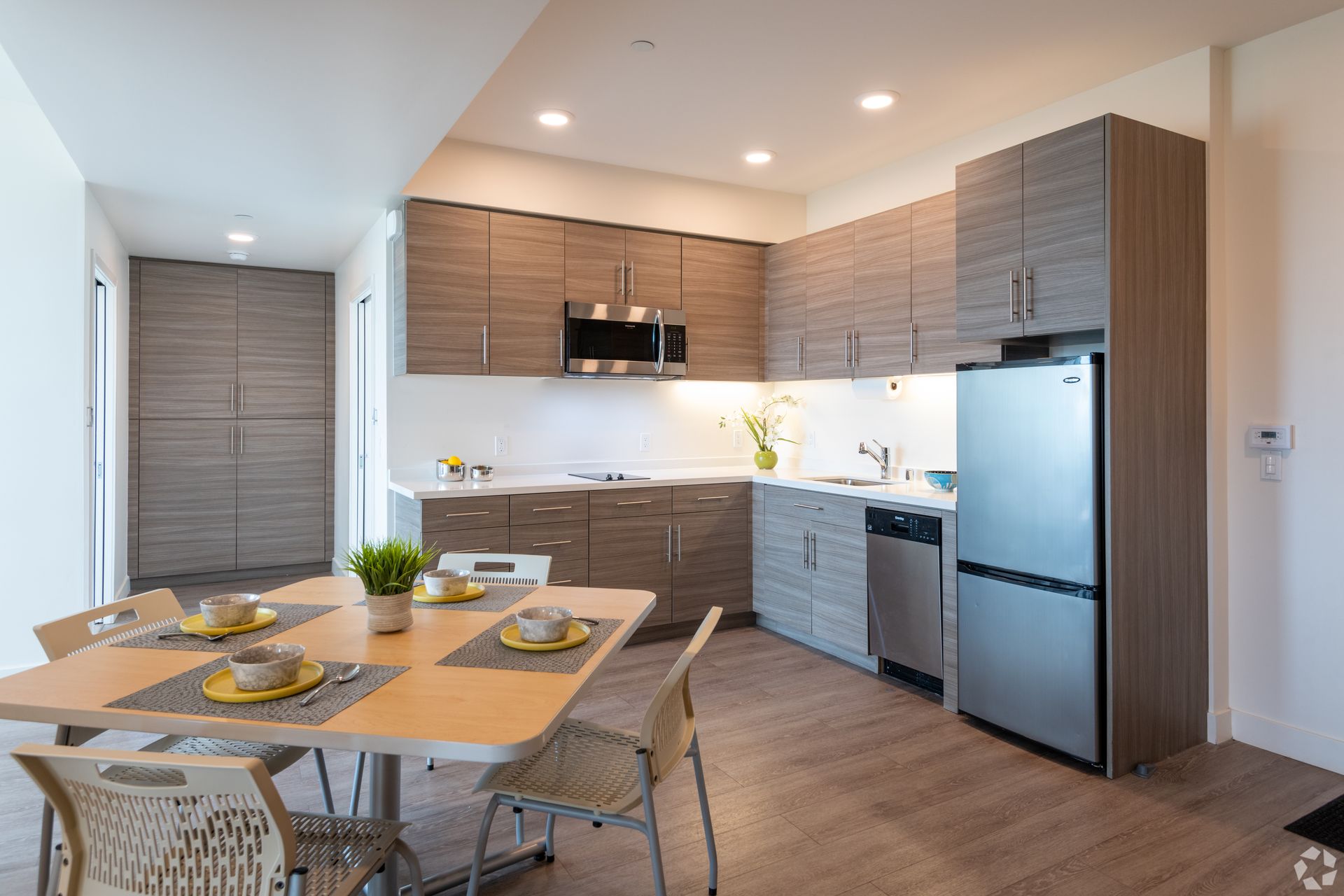 Panoramic Berkeley common area with dining table and kitchen