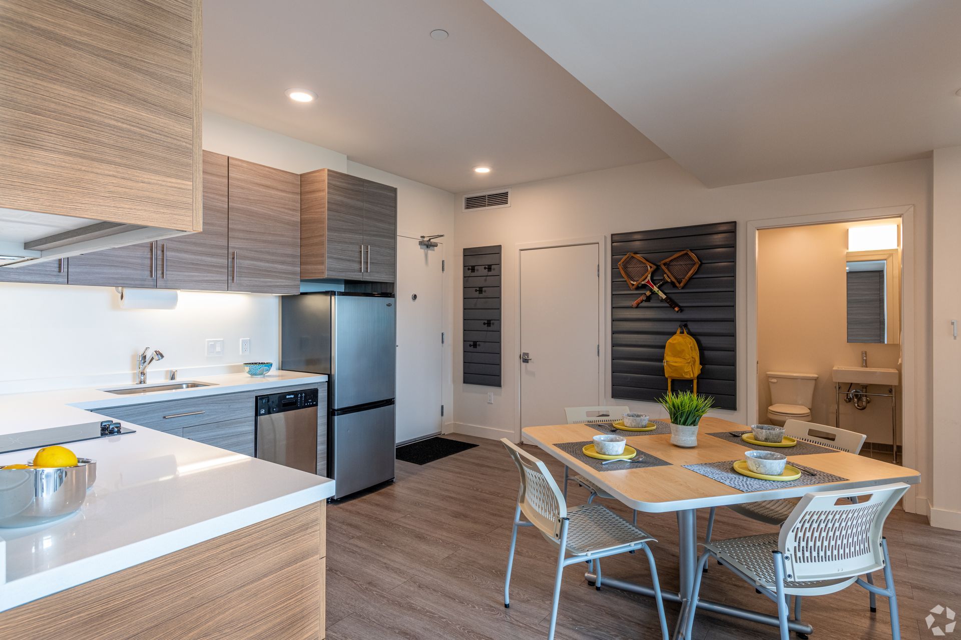 A kitchen and dining room in a apartment with a table and chairs.