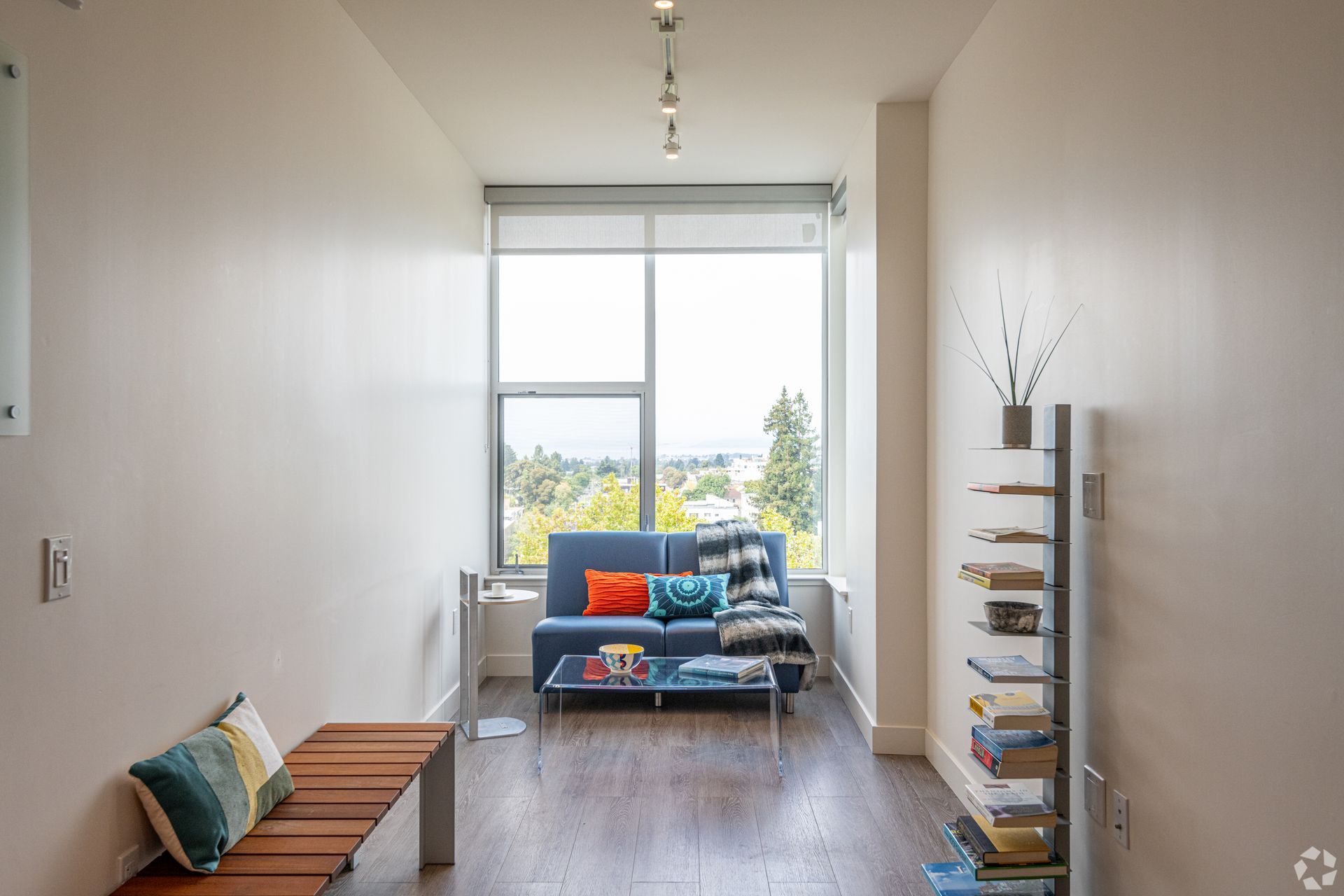 A living room with a blue couch and a large window
