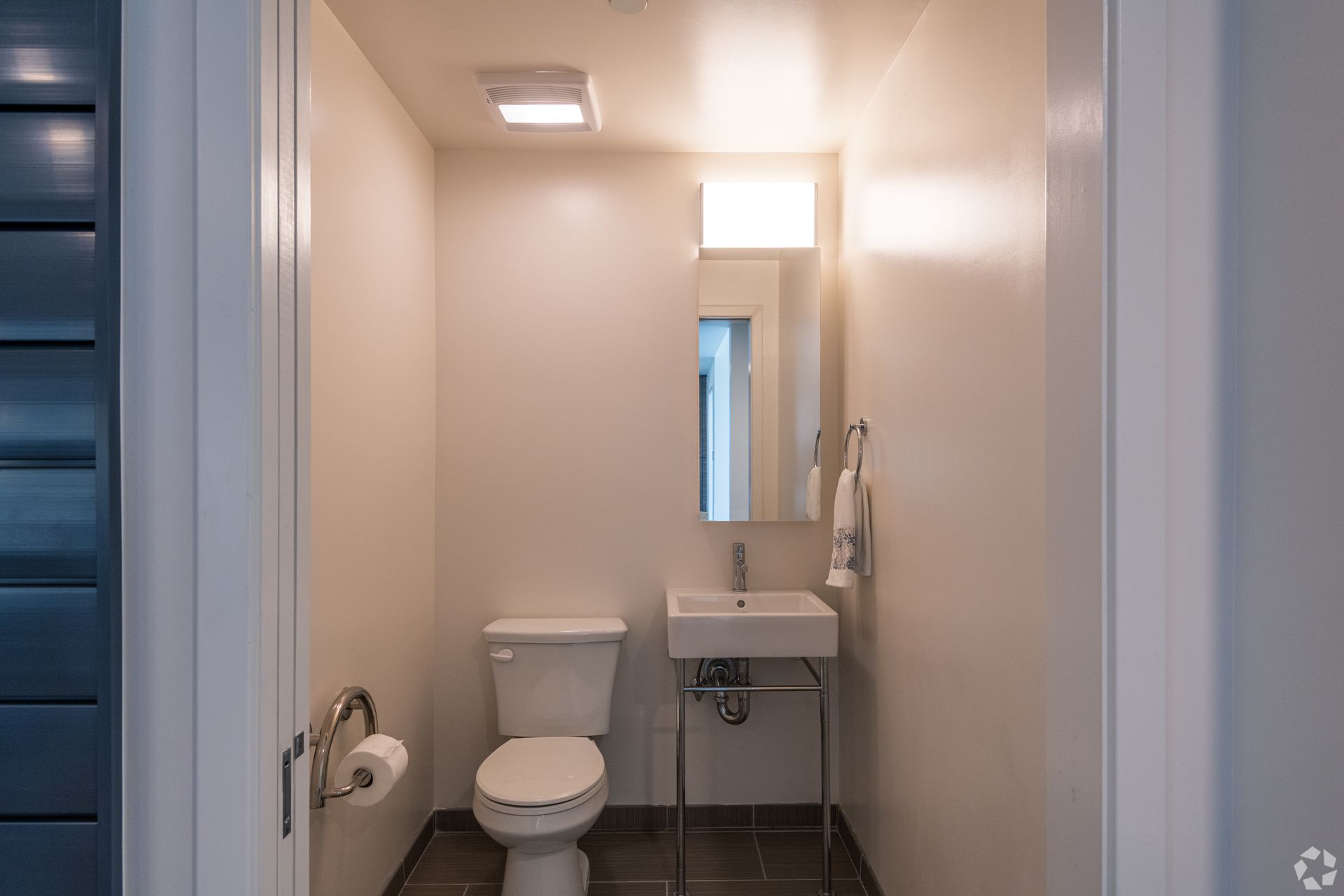 A bathroom with a toilet , sink and mirror.