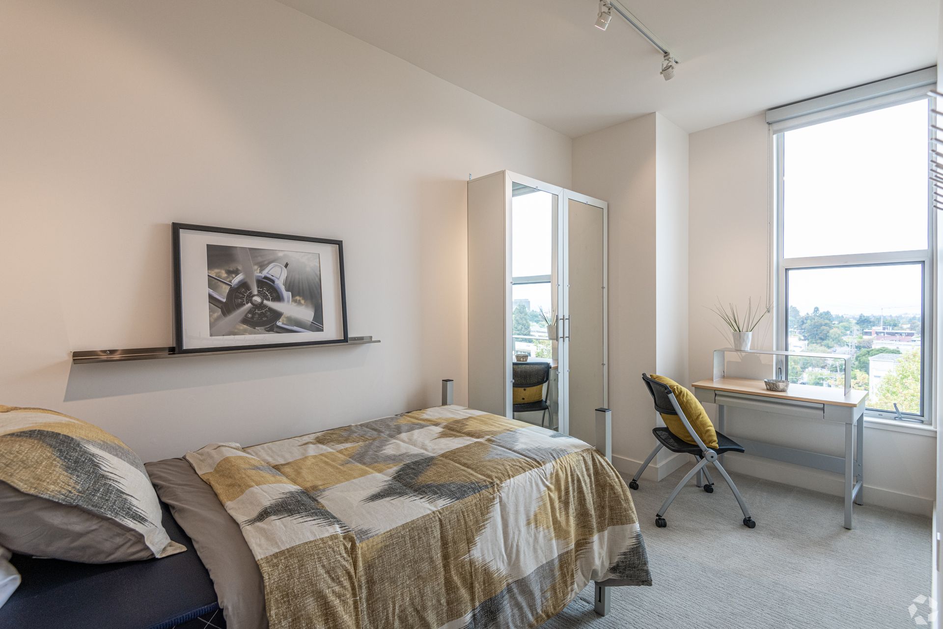 A bedroom with a bed , desk and window.