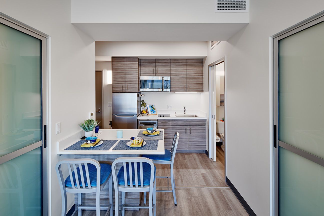 A kitchen with a table and chairs and a refrigerator.