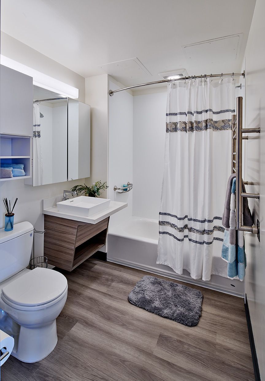 A bathroom with a toilet , sink , bathtub and shower curtain.