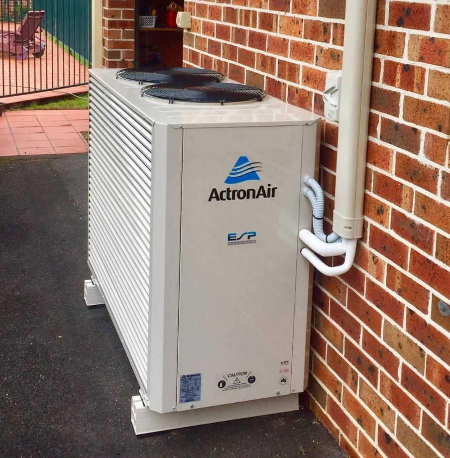 An AcrtonAir Air Conditioner Is Mounted on The Side of A Brick Building — Northernair in East Lismore, NSW