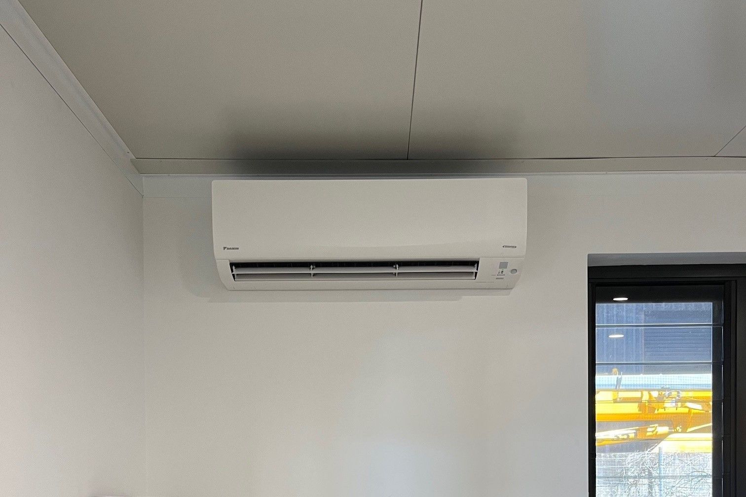 A White Split Type Air Conditioning Unit On A Room