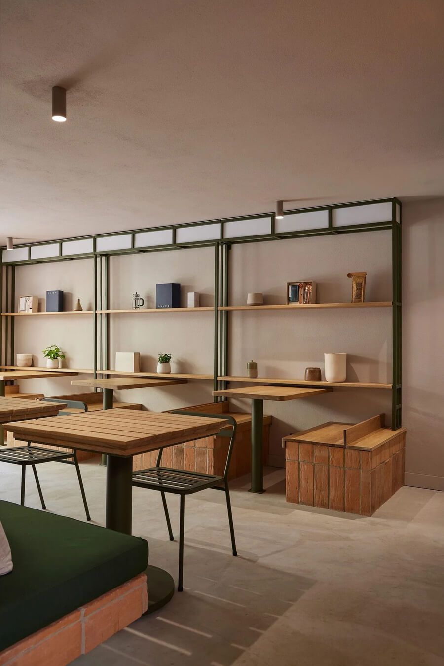 Espacio interior con mesas de madera y estanterías decorativas en un ambiente acogedor