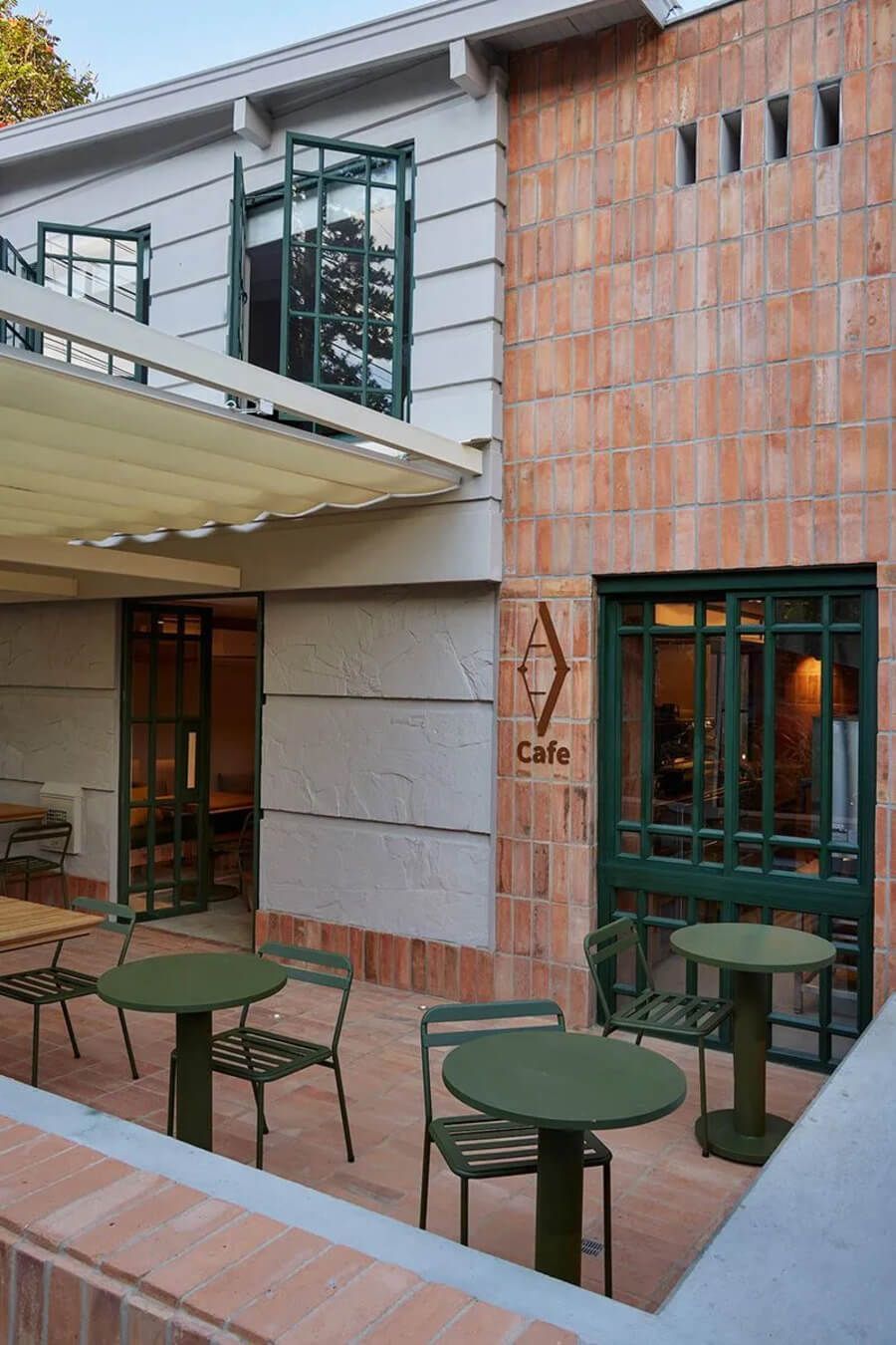 Terraza exterior con mesas y sillas bajo un toldo en el hotel, con diseño moderno y acogedor