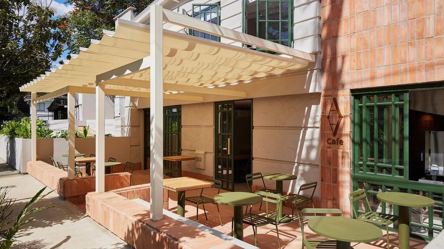 Terraza al aire libre con mesas y sillas bajo un toldo, en un espacio acogedor del hotel